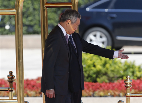 China's Premier Li Keqiang (back) shows the way to Singapore's Prime Minister Lee Hsien Loong during a welcome ceremony outside the Great Hall of the People in Beijing, Aug 26, 2013. Singapore PM starts official visit to China