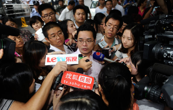 Lan He, legal advisor of Li Tianyi, is surrounded by media outside a court in Beijing, Aug 28, 2013. Army singer's son gang rape trial begins