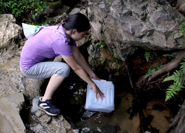 People like to drink the spring water from Baimo cave in Bama. A county for the ages