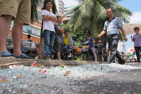 People stand outside the exploded store in Haikou, Sept 8, 2013. Gas leak causes blast, injuring 3 in Hainan