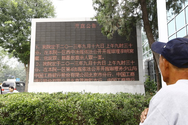 A man looks at a bulletin board briefing the baby-throwing case outside the Beijing No 1 Intermediate People's Court, Sept 16, 2013. Baby-throwing man stands trial