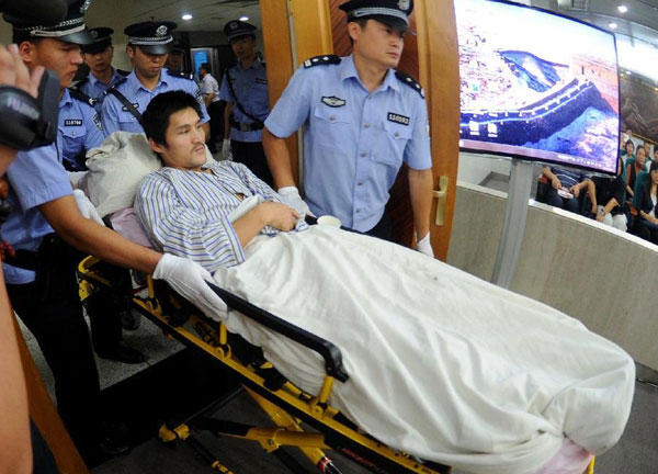 Ji Zhongxing, who is charged with causing a blast in the Beijing Capital International Airport in July, is escorted to the Beijing Chaoyang District People's Court, Sept 17, 2013. Beijing court hears airport blast case
