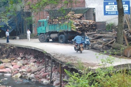 樂山夾江驚現(xiàn)“最牛公路” 路面僅靠3根木棍撐