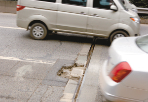 重慶內(nèi)環(huán)某路段1公里10多個坑 路邊10多輛車同時換胎