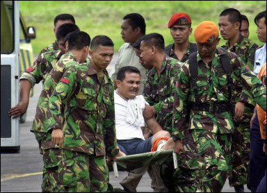 Indonesian troops evacuate an injured villager from Nias island. A lack of earth-moving gear on the isolated Indonesian islands closest to the epicentre of this week's massive earthquake means that many may perish trapped beneath the rubble(AFP/ATAR) 