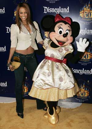 Supermodel Tyra Banks poses with Disney character Minnie Mouse during Disneyland's 50th anniversary party at the Disneyland theme park in Anaheim, California May 4, 2005. Walt Disney, founder of the Walt Disney Company and visionary behind the creation of Disneyland, opened the park on July 17, 1955.
