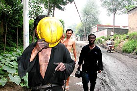 Miners, who managed to escape from a coal mine accident, avoid photographers on a street near their mine in Wenshu Township, Yuzhou City, central China's Henan province, August 3, 2005.