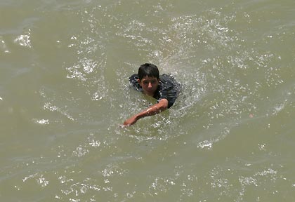 An Iraqi man swims to the bank after falling into the Tigris river from Baghdad's Al A'ema bridge during a stampede August 31, 2005. More than 600 Iraqi Shi'ites died in a stampede over a Tigris River bridge in Baghdad on Wednesday, panicked by rumors a suicide bomber was about to blow himself up, an Interior Ministry source told Reuters.