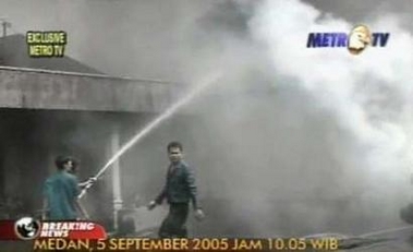 Firemen spray water toward the wreckage of an Indonesian Boeing 737-200 operated by Mandala Airlines which crashed just after takeoff from Medan city, on Indonesia's Sumatra island in this September 5, 2005 image taken from television footage.