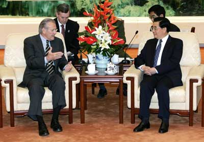 .S. Defense Secretary Donald Rumsfeld (L) talks to Chinese President Hu Jintao (R) inside the Great Hall of the People in Beijing October 19, 2005. China can dispel global worries about its strategic intentions and ensure future prosperity by opening up its political system, Rumsfeld said on Wednesday.