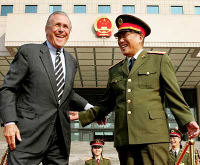Defense Secretary Donald Rumsfeld (L) and Chinese Defense Minister Cao Gangchuan share a light moment as they attend a welcoming ceremony at the Chinese Defense Ministry in Beijing October 19, 2005. China can dispel global worries about its strategic intentions and ensure future prosperity by opening up its political system, Rumsfeld told future Chinese leaders on Wednesday.