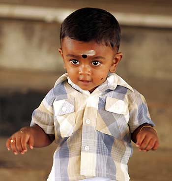 One-year-old tsunami survivor Abilass Jeyarajah, also known as "Baby 81", walks at a Hindu temple in Cheddipalaiyam village of Batticaloa, eastern Sri Lanka, October 19, 2005. Nearly 10 months after he was found among tsunami debris to become a beacon of hope and Sri Lanka's best-known survivor, "Baby 81" celebrated his first birthday on Wednesday with a trip to a Hindu temple.
