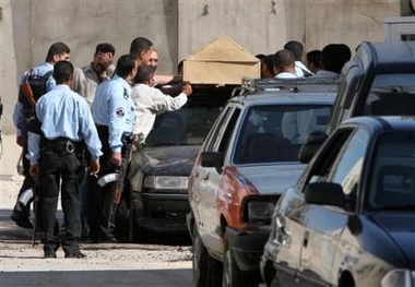 Iraqis place the coffin of Saadoun Sughaiyer al-Janabi, a defense lawyer in Saddam Hussein's mass murder trial, on a vehicle outside a morgue in Baghdad, Iraq, Friday, Oct. 21, 2005.