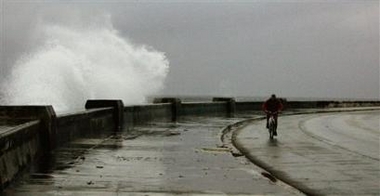 A cyclist passes a wave hitting the retaining wall of the Malecon boulevard in Havana before the threat of Hurricane Wilma, Saturday Oct. 23, 2005.