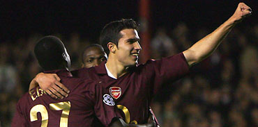 Arsenal's Robin Van Persie (R) celebrates with Emmanuel Eboue (L) and Lauren after scoring against Sparta Prague during their Champions League Group B soccer match at Highbury in London, November 2, 2005. Arsenal won the match 3-0.