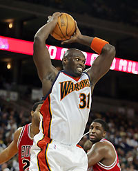 Golden State Warriors center Adonal Foyle (31) goes up for a rebound against Chicago Bulls center Othella Harrington (L) and forward Michael Sweetney (R) during the first quarter of their NBA game in Oakland, California, November 14, 2005.