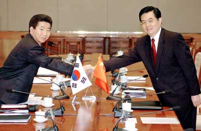 9China's President Hu Jintao (R) shakes hands with his South Korean counterpart Roh Moo-hyun during a meeting at the presidential Blue House in Seoul November 16, 2005. Hu arrived in Seoul on Wednesday for talks with South Korea's President Roh Moo-hyun ahead of this week's APEC summit.