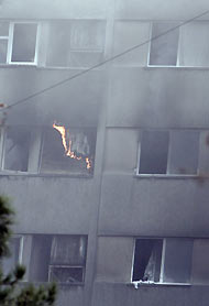 Smoke and flames rise from a building where a plane crashed in Tehran December 6, 2005. An Iranian military plane carrying at least 94 people crashed in flames into a Tehran apartment block on Tuesday, killing all those on board, police said.