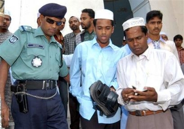 A policeman detains two suspected militants during Friday prayers at the National Mosque Baitul Mukarram in Dhaka, Bangladesh, Friday, Dec. 9, 2005.