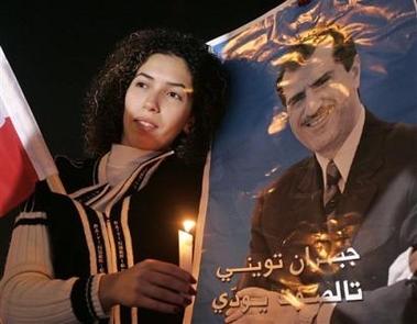 A Lebanese supporter of slain anti-Syrian journalist and lawmaker Gibran Tueni holds a poster of Tueni and a candle, in down town Beirut, Lebanon, Monday, Dec. 12, 2005.