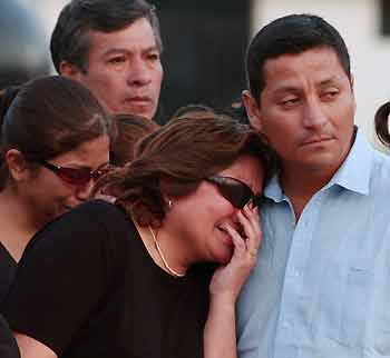 Relatives of Peruvian police officers killed by rebels in the Huanuco region cry as the coffins of the victims arrive at the airport in Lima December 21, 2005. Peruvian rebels killed eight policemen in an ambush in the country's cocaine-producing central jungle, the second deadly attack this month, the Interior Ministry said on Wednesday. Rebels attacked a police vehicle on a routine patrol in the remote Huanuco region on Tuesday night.