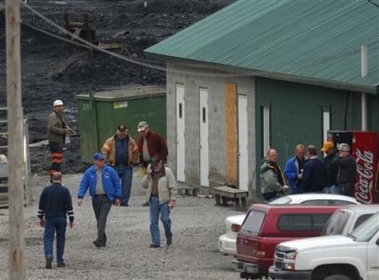 Investigators and miners gather Thursday, Jan. 5, 2006 near the entrance to the mine where 12 people were killed in an explosion in Tallmansville, W. Va.