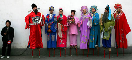 Chinese performers rest on stilts during celebrations for Lantern Festival at the Longhua temple fair in Shanghai February 12, 2006. Chinese worshippers visited the ancient temple to usher in the Year of the Dog. Lantern Festival marks the last day of the 15-day Spring Festival in China.