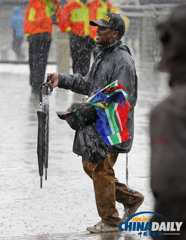 曼德拉追悼會(huì)現(xiàn)場:情侶為偉人海報(bào)打傘