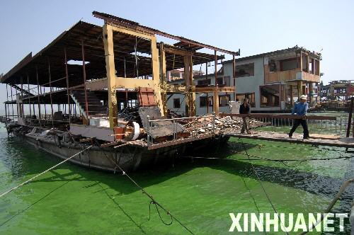 這是2007年8月23日，工人在拆除搭建在太湖中的無錫太湖馬山水上餐廳建筑群。位于太湖之濱的江蘇省無錫市有“太湖明珠”之稱。2007年春天，太湖藍藻暴發(fā)讓這座城市200萬市民經(jīng)歷了持續(xù)約一周的飲水危機。痛定思痛，無錫市除完善城鄉(xiāng)污水處理系統(tǒng)、減少湖面養(yǎng)殖、再造湖濱濕地等措施外，城區(qū)內(nèi)所有規(guī)模以下的“五小”企業(yè)（小鋼鐵、小水泥、小化工、小電鍍、小印染）一律關(guān)閉，同時大力整治“三高兩低”（高消耗、高污染、高危險、低產(chǎn)出、低效益）企業(yè)。 