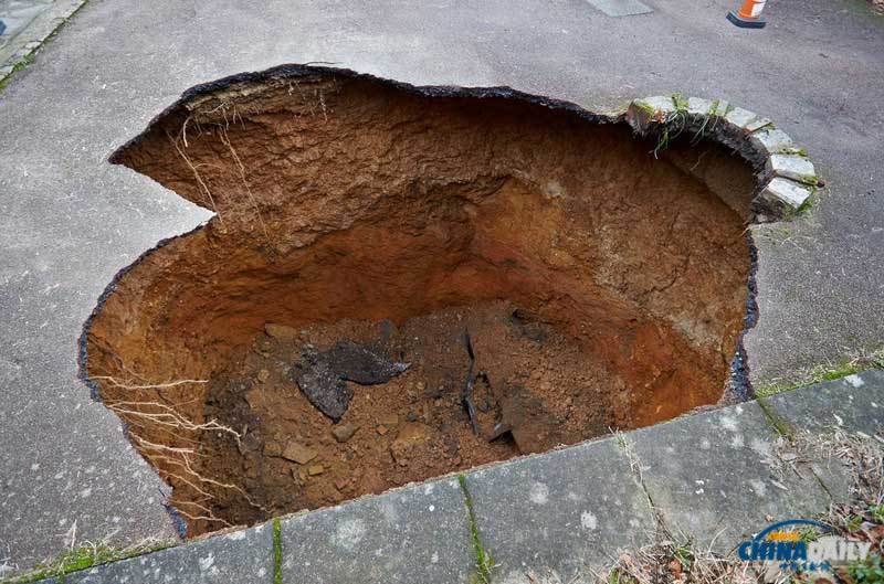 英國居民房屋前驚現(xiàn)大坑 汽車慘遭“吞噬”