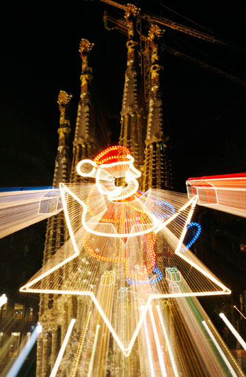 Christmas lights illuminate Barcelona's Avenida Gaudi, named after the Catalan artist and architect who designed the Sagrada Familia cathedral, which can be seen in the background, in Barcelona, December 24, 2006.