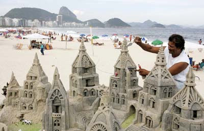 Sand sculptor Alonso Dias of Colombia creates a sand castle on Copacabana Beach in Rio de Janeiro February 21, 2006. On crowded Copacabana beach, carnival tourists both young and old stop to snap photos of magical sand cities and seductive sculptures of sunbathing girls.