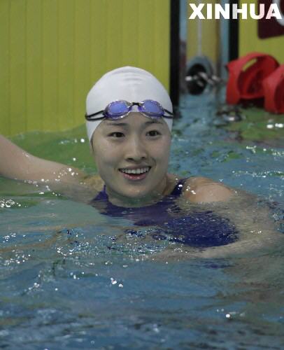 Chinese Olympic champion Luo Xuejuan waves after the women's 50m breaststroke swimming event at the 4th East Asian Games in Macao, south China, Nov. 2, 2005. Luo won the gold medal of the event in 31.67 seconds Nov. 2.