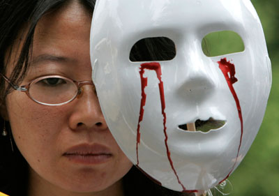 A protester holds a mask during an anti-war and anti-U.S. rally, demanding for a negotiation between the U.S. government and the Taliban for the safe return of South Korean hostages in Afghanistan, in front of the U.S. embassy in Seoul August 1, 2007. Afghanistan's Taliban set a fresh deadline of 0730 GMT Wednesday to free prisoners of the insurgent group in exchange for the lives of 21 South Korean hostages, a demand the Afghan government has rejected.