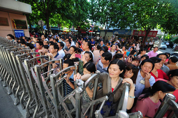 Parents wait outside a test site on the first day of college entrance examination, in Nanning, South China's Guangxi Zhuang autonomous region, June 7, 2013. Big exam day kicks off