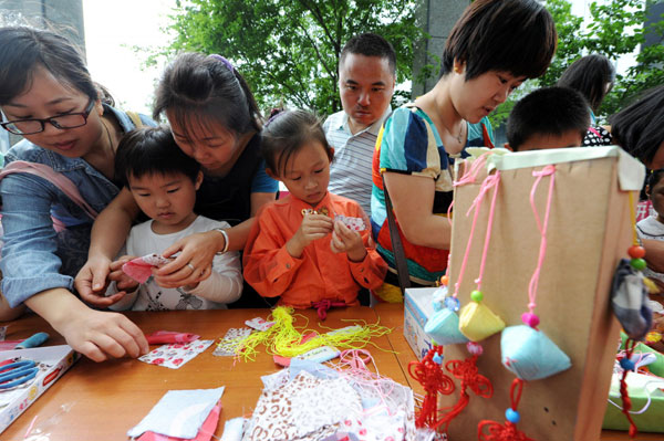 Families participate in a Dragon Boat Festival activity in Hangzhou, East China's Zhejiang province, June 11, 2013. Dragon Boat Festival celebrated around the country