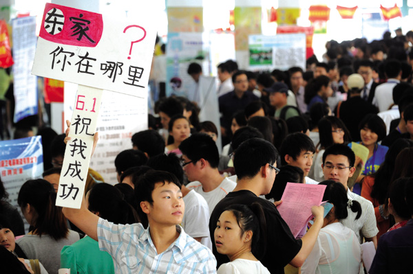 A college graduate holds a placard with Chinese characters that read 'Where are you, my boss?' at a job fair in Bozhou, Anhui province. Zhang Yanlin / for China Daily Graduates face grim hunt for work