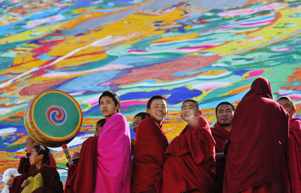 Monks pose for a photo on Friday in front of a thangka - a Tibetan scroll painting - during a Tibetan Buddhism festival at the Labrang Monastery in Gansu province. The monastery, which was founded in 1709, is a major venue for Buddhist ceremonies. Colorful celebration