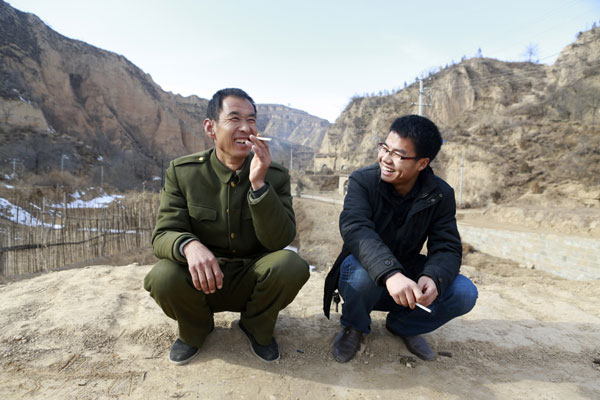 Zhang Qiang (right) talks with a resident of Liangjiahe village in Shaanxi province. Zhang is one of 300,000 college graduates who have become village officials since China launched a nationwide program in 2009. He is now assistant to the village Party chief. Feng Yongbin / China Daily Villagers draw inspiration from Xi