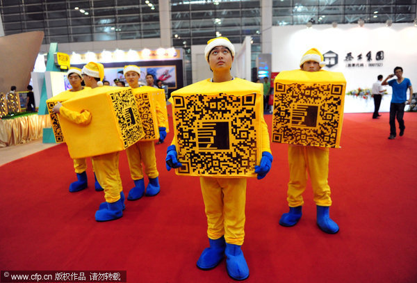 Staff from a real estate project wear fancy cube costumes in Fuzhou, East China’s Fujian province, May 26, 2012. The beauty and beasts of selling hot houses
