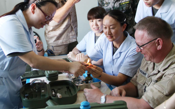 Nurse Zhang Yongmei (left), who is on a peace mission in Beirut, shows a medical kit of traditional Chinese medicine to her counterparts from Belgium during an exchange activity. YANG SHENGCHAO / XINHUA Nurses embark on journey to the West