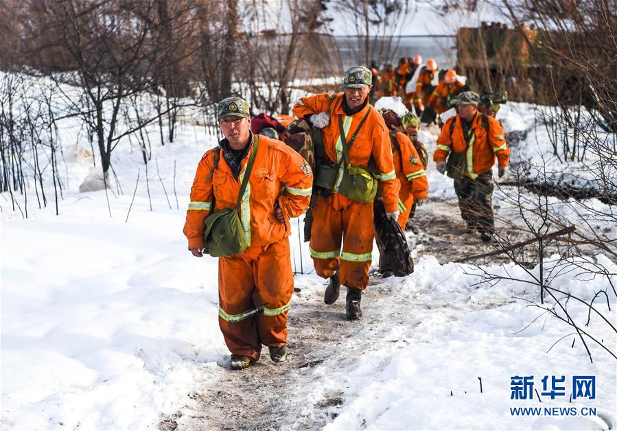 Firefighters withdraw from snow-covered forest