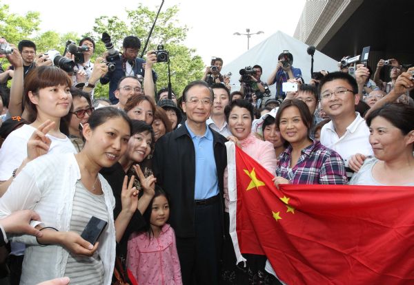 Chinese Premier Wen Jiabao (C) poses for a photo with Chinese overseas at a gymnasium serving as a makeshift shelter in Fukushima, Japan, May 21, 2011. Fukushima was hit hard by the earthquake and tsunami on March 11. Premier Wen visits disaster-ravaged Fukushima