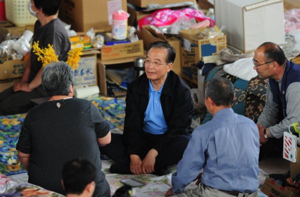 Chinese Premier Wen Jiabao (C) chats with displaced people at a gymnasium serving as a makeshift shelter in Fukushima, Japan, May 21, 2011. Fukushima was hit hard by the earthquake and tsunami on March 11. Premier Wen visits disaster-ravaged Fukushima