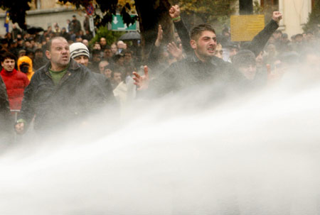 Opposition supporters shout as police officers use a water cannon during a rally in front of the parliament building in Tbilisi Nov. 7, 2007. 
