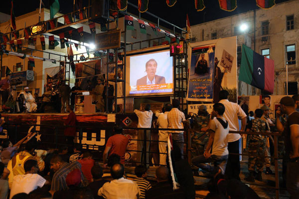 People watch a speech by Libyan defector Abdul Salam Galod, a dissident of Muammar Gadhafi, near the courthouse in Benghazi, August 21, 2011. Libya rebels say they control parts of Tripoli