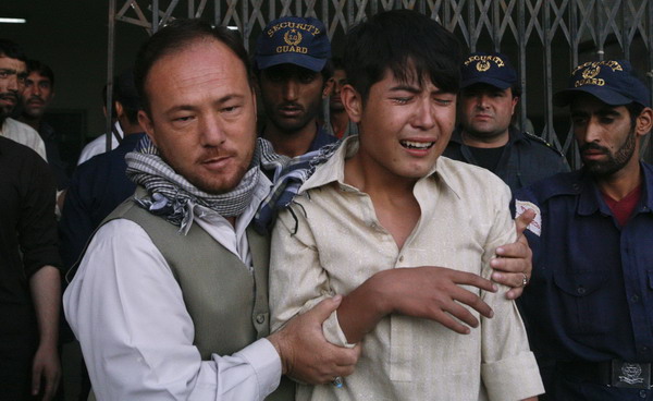 An ethnic Hazara Shi'ite man is comforted by his relative after he arrived at the local hospital in Quetta, to find a family member shot dead, Sept 20, 2011. At least 26 Shi'ite pilgrims killed in Pakistan