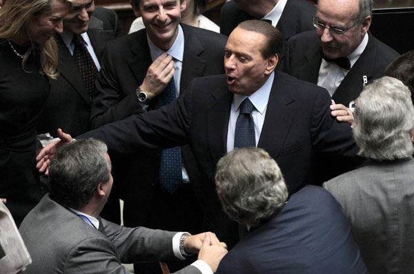Italian Prime Minister Silvio Berlusconi (C) reacts at the lower chamber of the deputies in Rome Oct 14, 2011. Berlusconi wins confidence vote but still weak