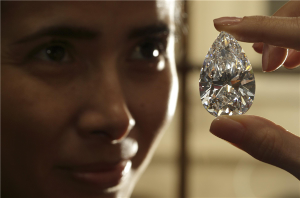 A Christie's member of staff displays a pear-shaped, D color, flawless diamond of 101.73 carats during an auction preview in Geneva, April 30, 2013. 101.73-carat diamond to be auctioned for over $20 million