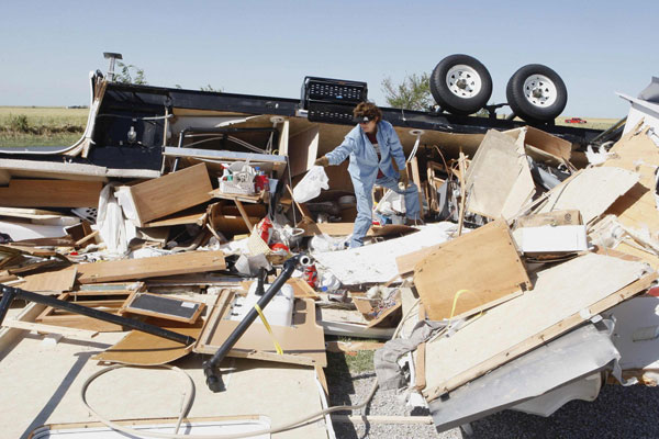 Mikie Hooper of Tuttle, Oklahoma, collects her belongings from her RV which was destroyed by a tornado in El Reno, Oklahoma, June 1, 2013. Oklahoma tornadoes kill at least nine